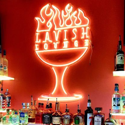 National Black Business Month Celebrated in Harriet Tubman's Chosen Home Town Lavish Lounge Logo of a neon wine glass with fire coming out f the top on a red wall