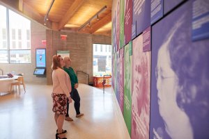 Interior of a building with two women looking at art on the walls