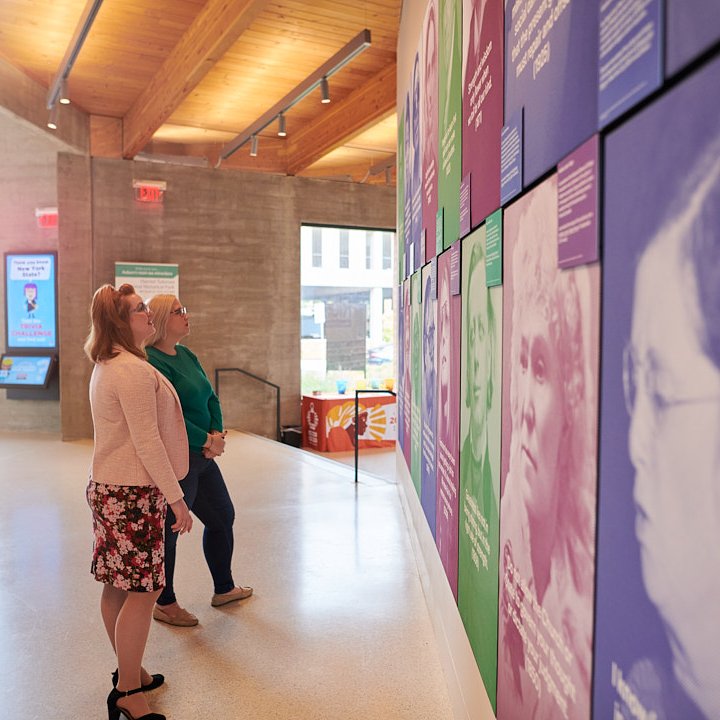 Interior of a building with two women looking at art on the walls