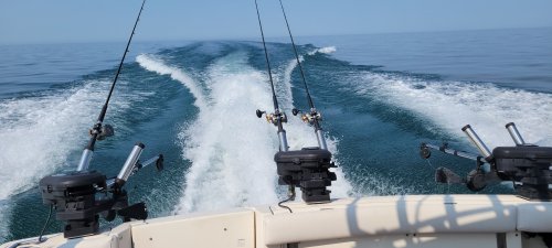 boat traveling in the blue waters of Lake Ontario with fishing lines off the back