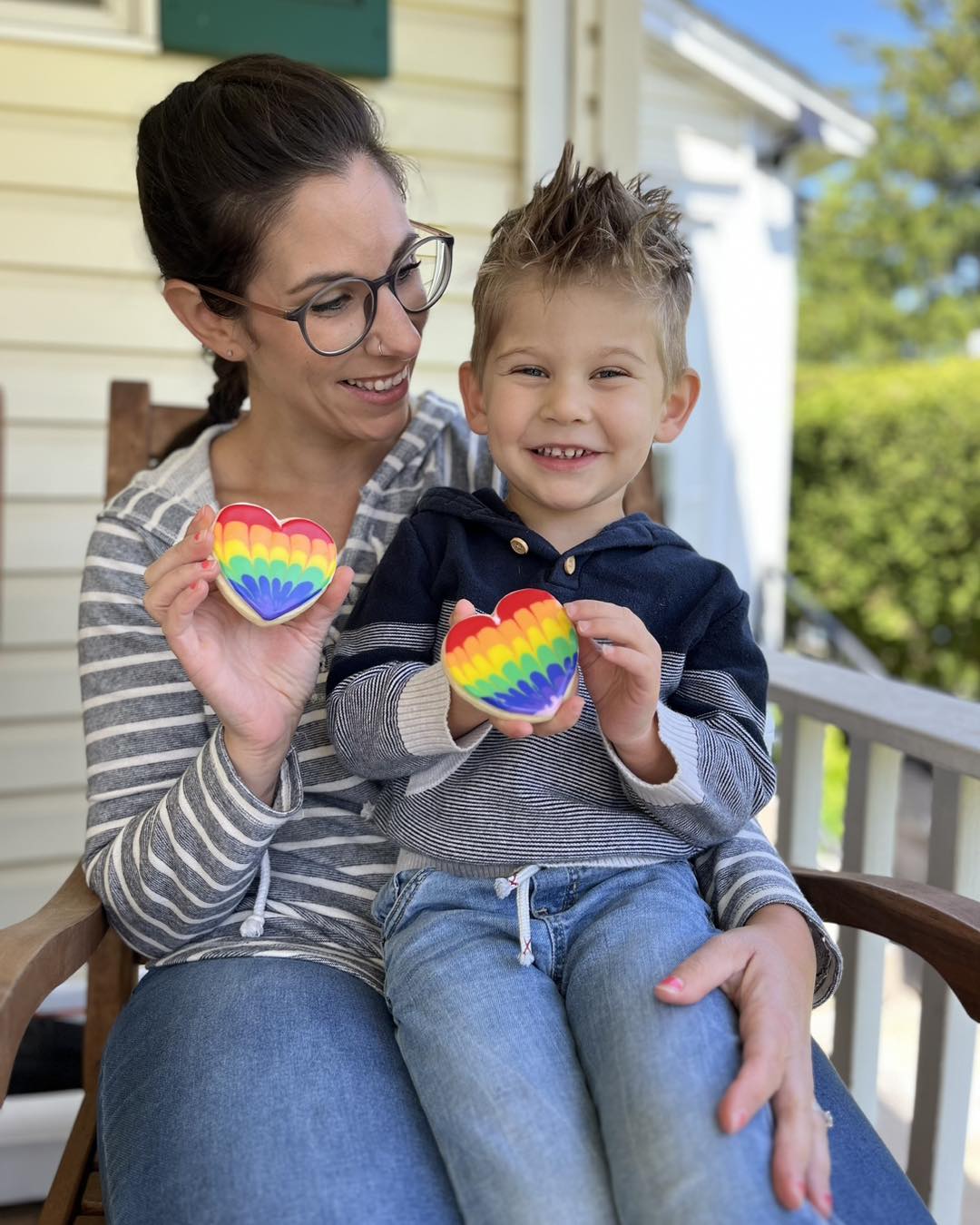 Home baker sitting on a porch with young child holding a cookie