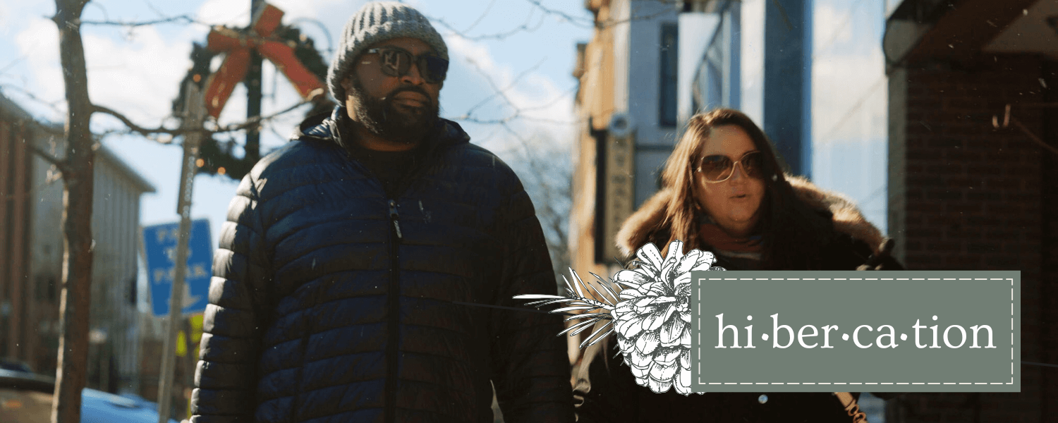 Hibercation -Retail Specials a man and a women walking along a city street decorated for the Christmas season. Both are enjoying a Hibercation