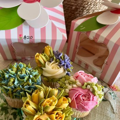 Picture of four cupcakes decorated with flowers in pastel colors