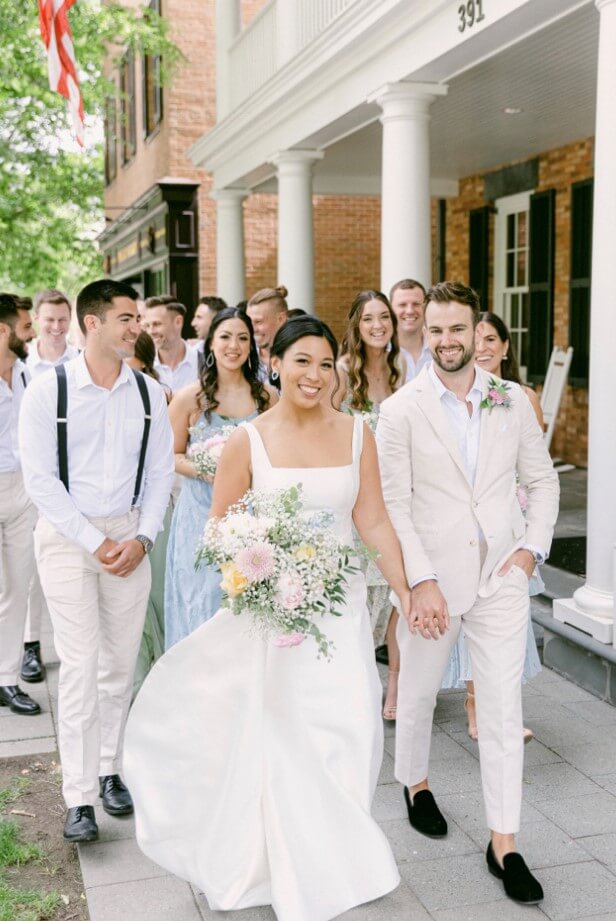 Bridal party walking out side the Aurora Inn during the summer