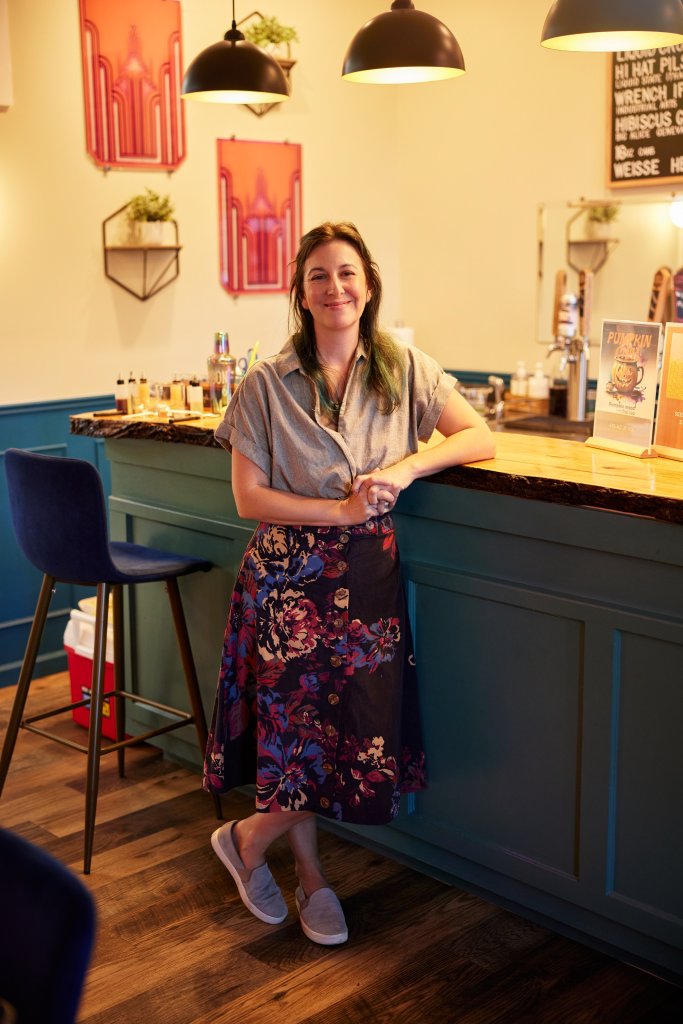 Women in Craft Beverage: Pioneers of Cayuga County Owner of Combgrown Mead standing in front of a bar