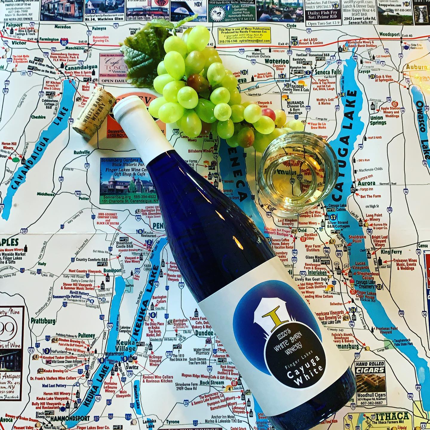 A bottle black bottle of wine with a white label from Izzo's White Barn Winery