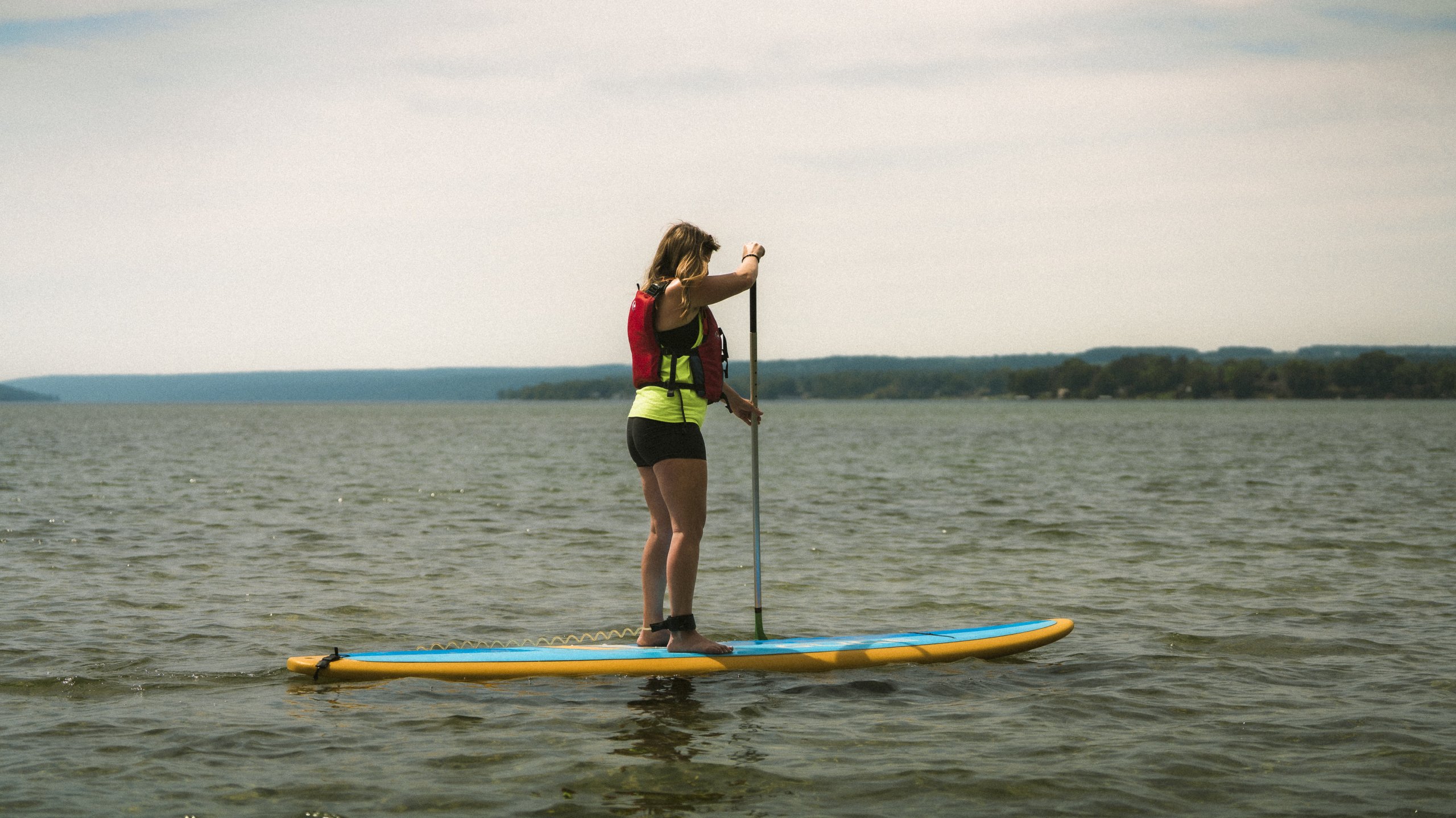 Family Friendly Outdoor Adventures in Cayuga County women on a paddle board on Owasco Lake