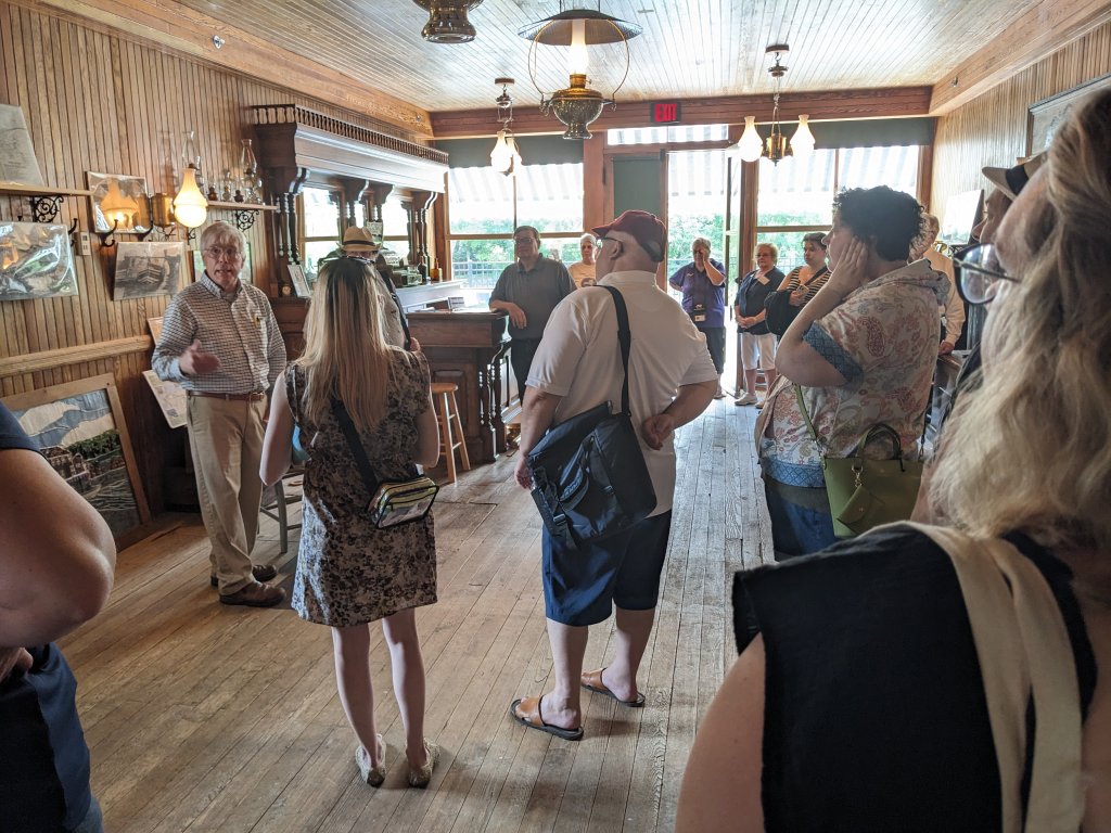 Celebrating Disability Pride Month: Building a More Inclusive Cayuga County Group of people listening the to docent talk about the Erie Canal and the old tavern building they are in.