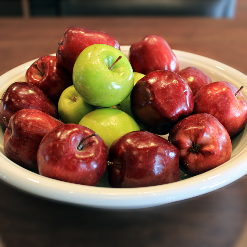 Experience Apple Picking 2024 White bowl of red apples on a table that were freshly picked