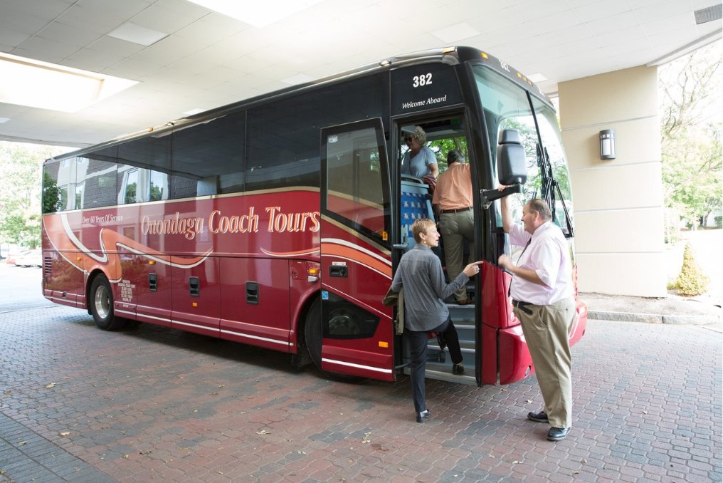 Visitors board a Onondaga Coach Tours bus.