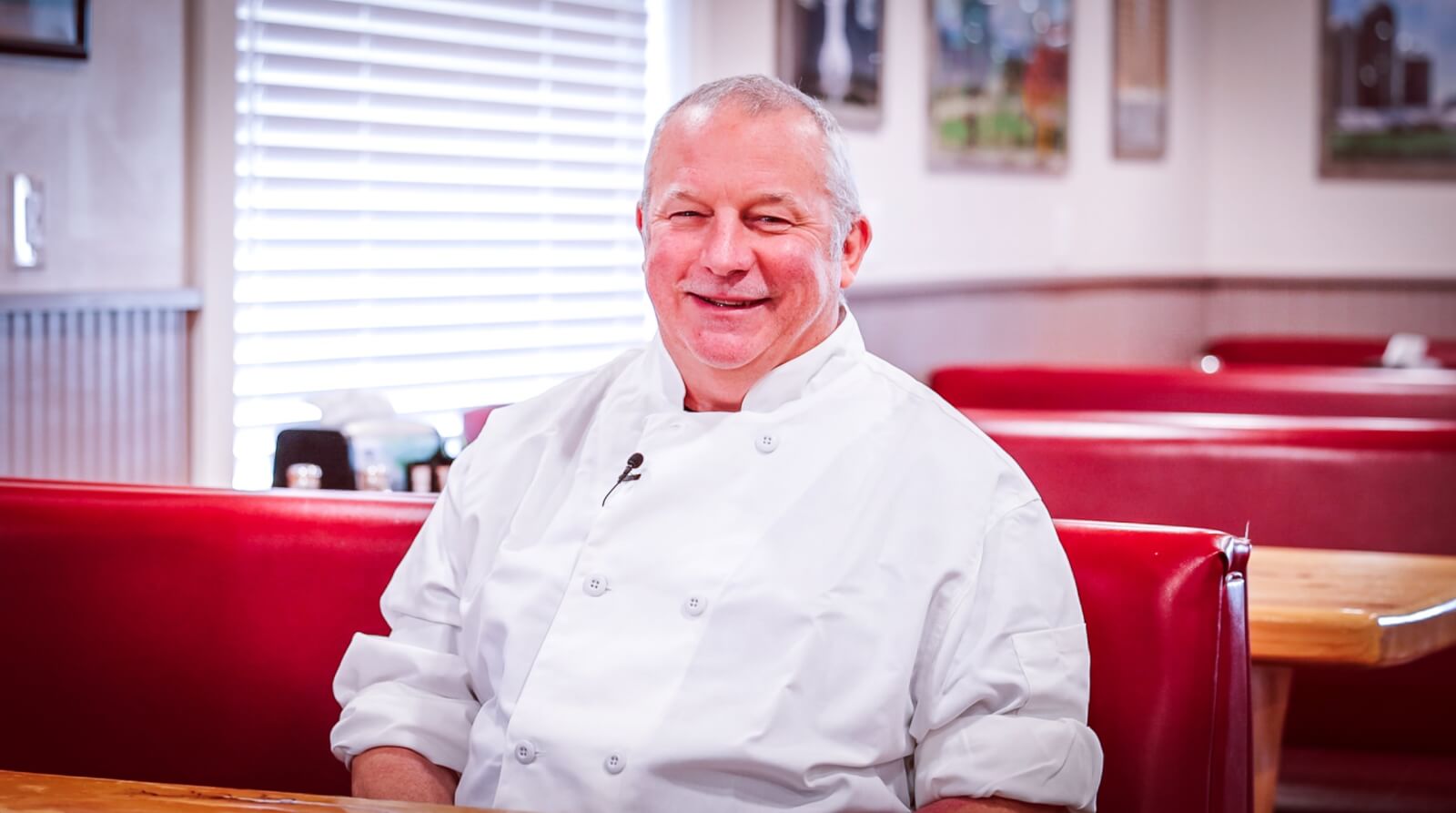 photo of a male chef sitting in a booth